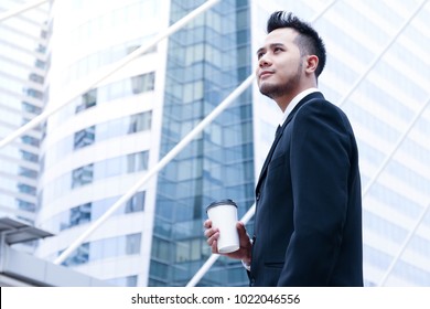 A Portrait Business Man Standing And Looking Forward With Holding Glass Or Some Drink Or Coffee In Hand As Confident Or Smart Success Concept