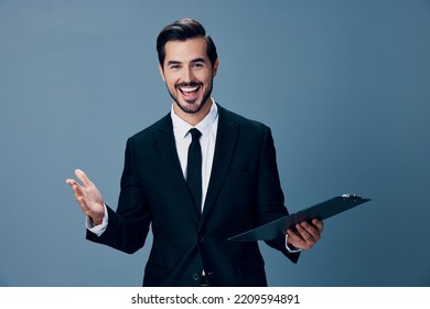 Portrait of a business man in a stylish suit smile with teeth with a tie beautiful face on a blue isolated background with a tablet in his hands. Business concept young businessman startup copy place - Powered by Shutterstock