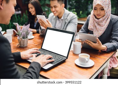 Portrait Of Business People Busy Working With Team At A Cafe | Focus On Laptop