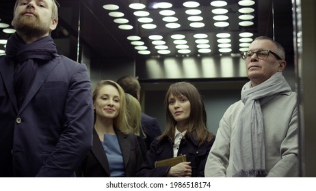 Portrait of business people in elevator. Business center workers riding in modern elevator. Work colleagues standing in elevator at office - Powered by Shutterstock