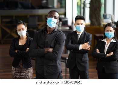 Portrait Of Business Team Waring Face Mask Inside Modern Office. Group Of Diverse Business People With African American Businessman Leader.