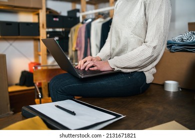 Portrait of a business woman checking customer orders on the laptop - Young female sells products online- Millennial use websites to market second-hand clothing they don't use - Start up concept - Shutterstock ID 2131671821