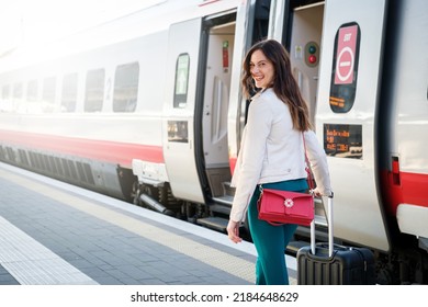 Portrait of a business woman commuter walking in a train station or airport going to boarding gate with hand luggage - Powered by Shutterstock