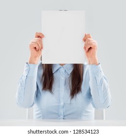 Portrait Of Business Woman Holding Blank Paper Sheet In Front Of Her Face