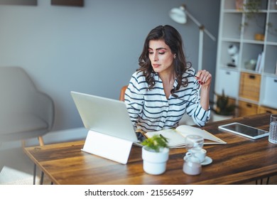 Portrait Of A Business Woman At Home With A Laptop On The Table. 30-year-old Girl Connected Online. The Concept Of Teleworking