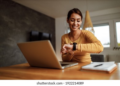 Portrait of business woman, looking at her wrist watch.