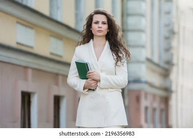 The Portrait Of A Business Woman With A Notebook In Her Hand.  Smartly Dressed Girl Outside. Successful White European Woman