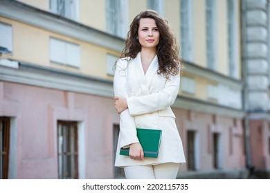 The Portrait Of A Business Woman With A Notebook In Her Hand.  Smartly Dressed Girl Outside. Successful White European Woman