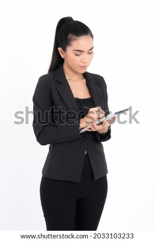 Portrait business woman using tablet digital device wearing a black suit at studio shot isolated on white background. Pretty female model. Confident professional office worker.