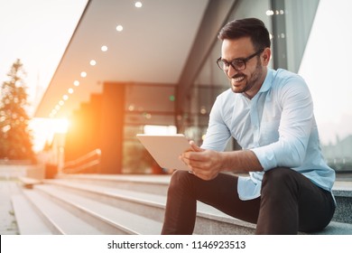 Portrait of businessman in glasses holding tablet - Powered by Shutterstock