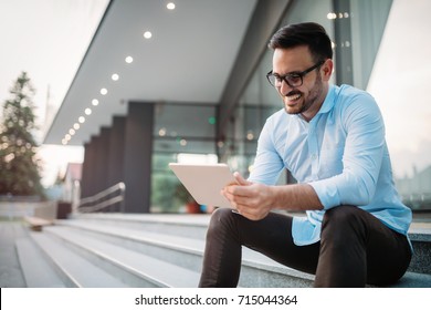 Portrait of businessman in glasses holding tablet - Powered by Shutterstock