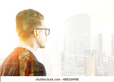 Portrait Of Businessman In Glasses Looking At Big City Skyscraper. Concept Of Large Company Employee.  Toned Image. Double Exposure.