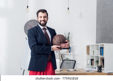 Portrait Of Businessman In Jacket Holding Basketball Ball In Office