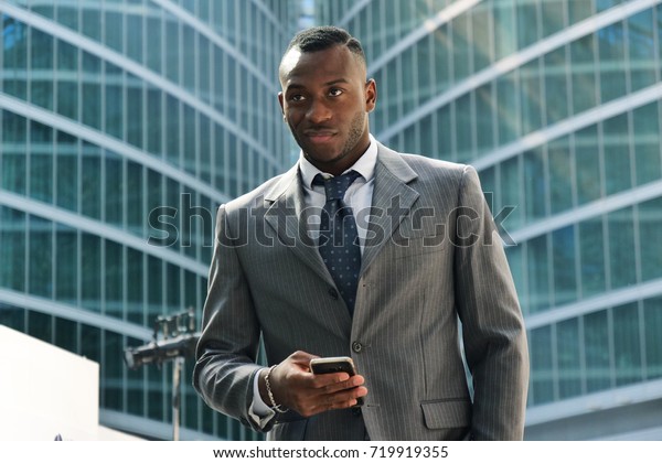 Portrait of a\
businessman looking at the future proud of his success and smiling.\
On skyscrapers background with glazed windows. Concept of:\
business, economy, finance, dreams,\
future.