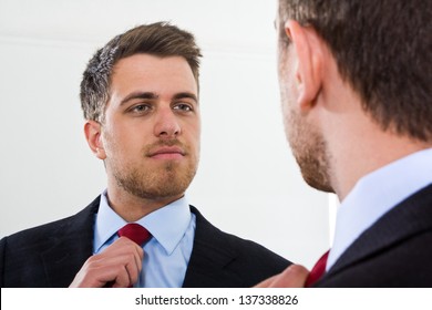 Portrait Of A Businessman Looking At Himself In The Mirror