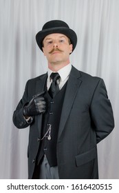 Portrait Of Businessman With Moustache In Dark Suit Standing At Respectful Attention. Classic And Eccentric English Gentleman Stereotype. Film Noir Spy Or British Butler.