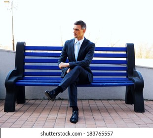 Portrait Of A Businessman Sitting On Bench