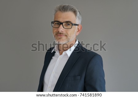 Portrait of businessman standing on grey background, isolated