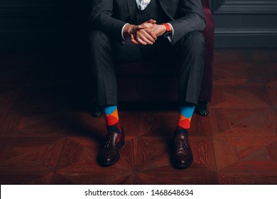 Portrait Of A Businessman In Strict Gray Suit And Colorful Multi Colored Socks. Business And Success Concept.