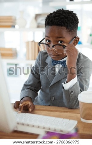 Portrait of businessman using computer at desk in office