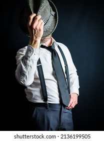 Portrait Of Businessman In White Dress Shirt And Suspenders Putting On Old Fedora Hat. Vintage Style And Retro Fashion Of Classic Detective.