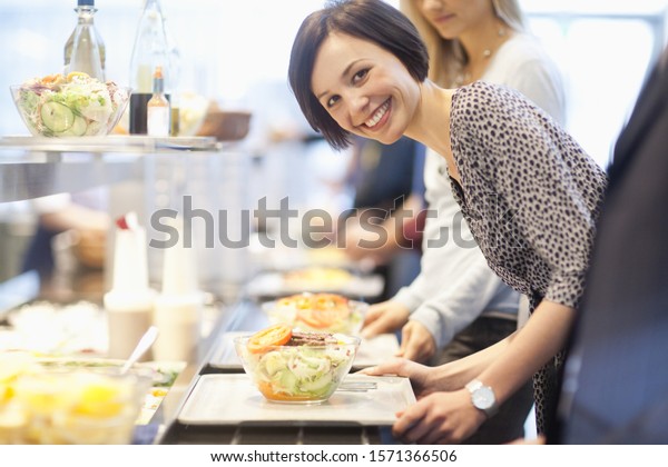 Portrait\
of businesswoman in lunch line at work\
cafeteria