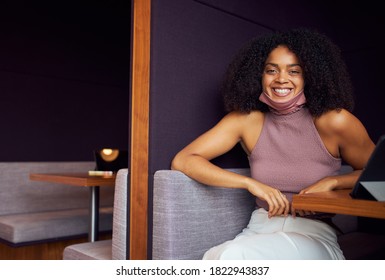 Portrait Of Businesswoman With Mask Working In Socially Distanced Cubicle In Office During Pandemic