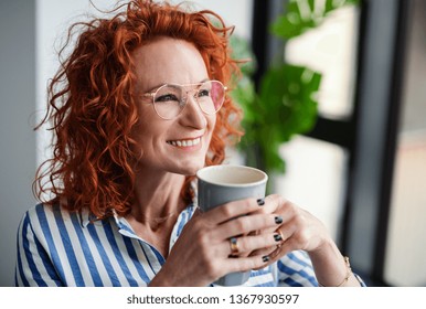 A portrait of businesswoman in an office, holding a cup of coffee. - Powered by Shutterstock