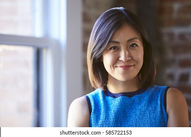 Portrait Of Businesswoman In Office Standing By Window
