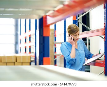 Portrait of a businesswoman on the phone and checking inventory in warehouse - Powered by Shutterstock