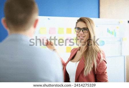 Portrait of businesswoman put colourful stickers on board, prepare presentation, set goals for next year. Female go through strategy. Business, aim concept