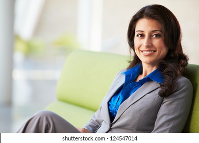 Portrait Of Businesswoman Sitting On Sofa In Modern Office