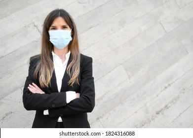 Portrait of a Businesswoman in suit, standing in street wearing face mask looking at camera.  - Powered by Shutterstock