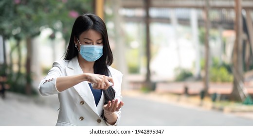 Portrait Of Businesswoman Wearing Mask Sanitizing Hands At Post Pandemic Office, Copy Space.