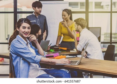 Portrait Of Businesswoman Working With Computer Over The Photo Blurred Of Group Of Asian And Multiethnic Business People With Casual Suit In The Modern Office, People Business Group Concept