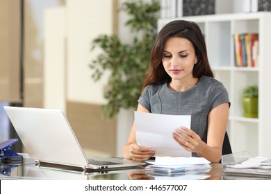 Portrait of a businesswoman working at office reading a letter in a desktop  - Powered by Shutterstock