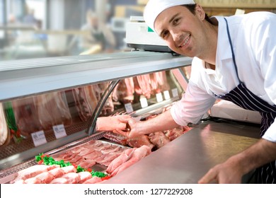 Portrait of butcher wearing apron arranging display cabinet in store - Powered by Shutterstock