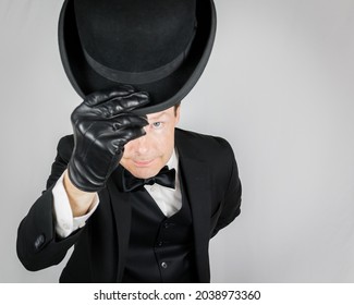 Retrato de Butler en traje negro educadamente doblando y deslumbrando sombrero de Bowler en fondo blanco. Concepto de industria de servicios y hospitalidad profesional. Caballero inglés clásico.