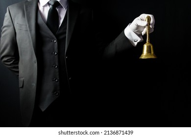 Portrait of Butler in Dark Suit and White Gloves Holding Brass Bell. Concept of Service Industry and Professional Hospitality.