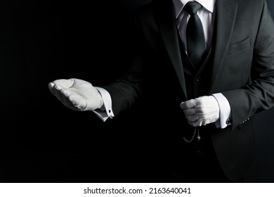 Portrait of Butler in Dark Suit and White Gloves Offering Helping Hand. Concept of Service Industry and Professional Courtesy.