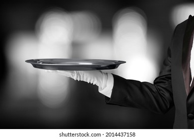 Portrait of Butler or Waiter in Dark Suit and White Gloves Holding Silver Tray. Service
