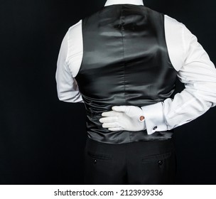 Portrait of Butler or Waiter in White Gloves and Black Vest Standing With Hand Behind Back. Elegant Concept of Hospitality Industry.