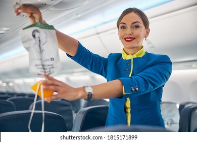 Portrait Of Cabin Crew Holding Up The Oxygen Mask During The Safety Demonstration On Board Commercial International Airlines