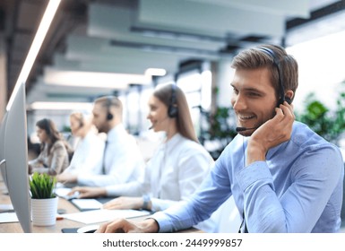 Portrait of call center worker accompanied by his team. Smiling customer support operator at work - Powered by Shutterstock