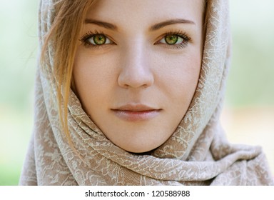 Portrait of calm beautiful young woman in head scarf close up, against green of summer park. - Powered by Shutterstock