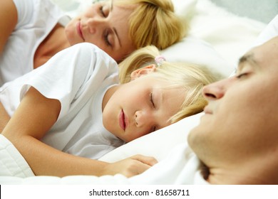 Portrait Of Calm Family Sleeping With Focus On Cute Child