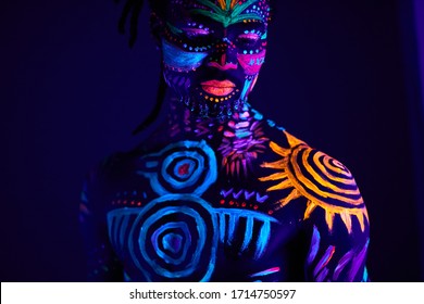 portrait of calm young african male with UV body art, muscular man with unusual fantastic prints on naked skin