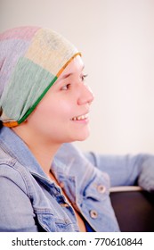 Portrait of cancer woman wearing headscarf in a blurred background, side view