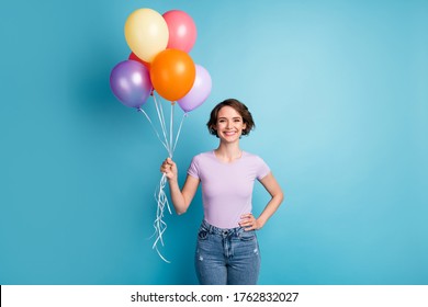Portrait of candid content girl hold many air balloons enjoy holiday party wear casual style clothes isolated over blue color background