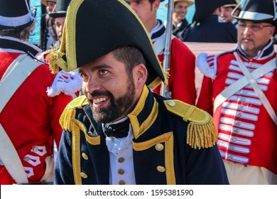 Portrait Of A Captain Of The 1800s Royal Navy. Reenactor Wearing A British Uniform, Blue Frock Coat And Bicorn Hat. People Behind With The Royal Marines Uniform. Málaga, Spain - October 26, 2014.